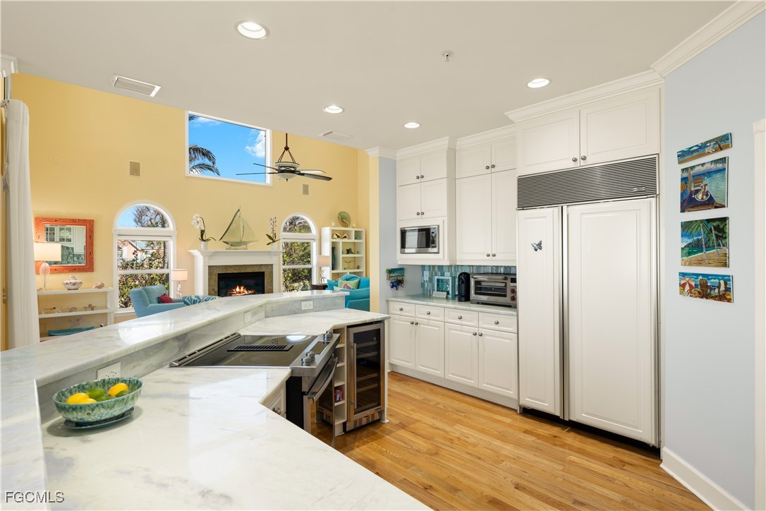 15899 Captiva Drive Captiva, FL 33924 - Photo 15 of 47 a kitchen with stainless steel appliances a stove a refrigerator a sink a refrigerator white cabinets with wooden floor