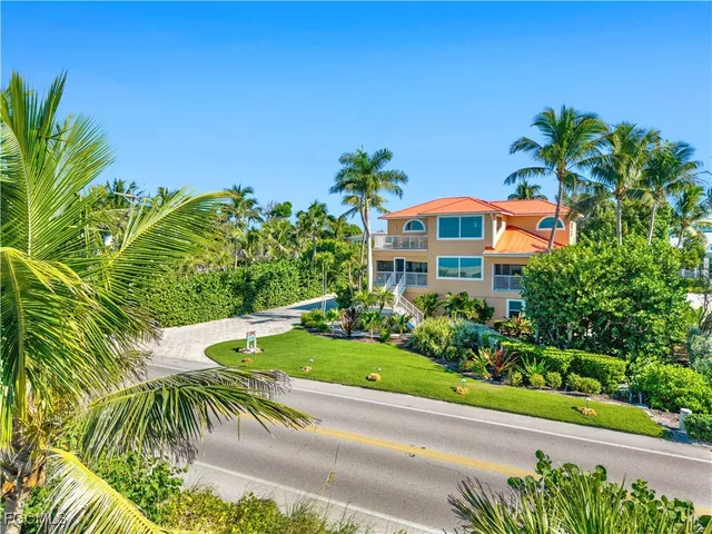 a front view of a house with a yard and fountain