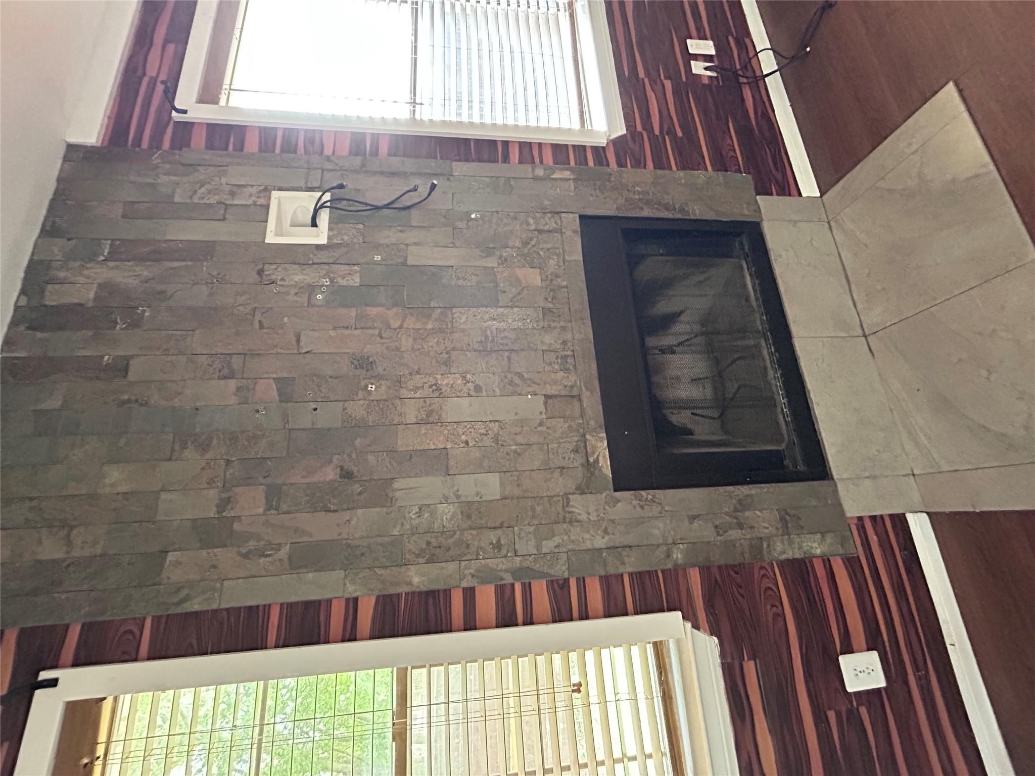 5708 Spring Meadow Road, Unit B Austin, TX 78744 - Photo 6 of 23 Detailed view of a fireplace, wood walls, wood finished floors, and a barn door