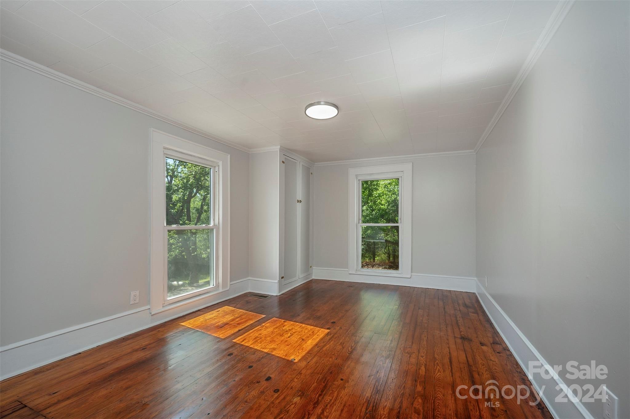 261 West 3rd Street Rutherfordton, NC 28139 - Photo 8 of 31 an empty room with wooden floor and windows