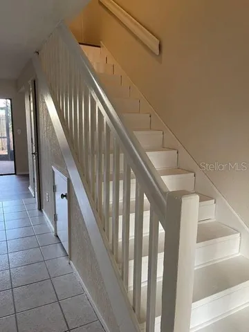 a view of staircase with railing and white walls