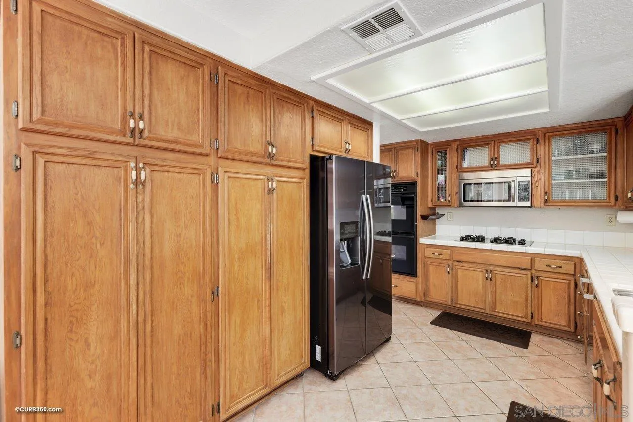 5138 Vía Madrid Oceanside, CA 92057 - Photo 11 of 32 a kitchen with stainless steel appliances granite countertop a refrigerator and a sink
