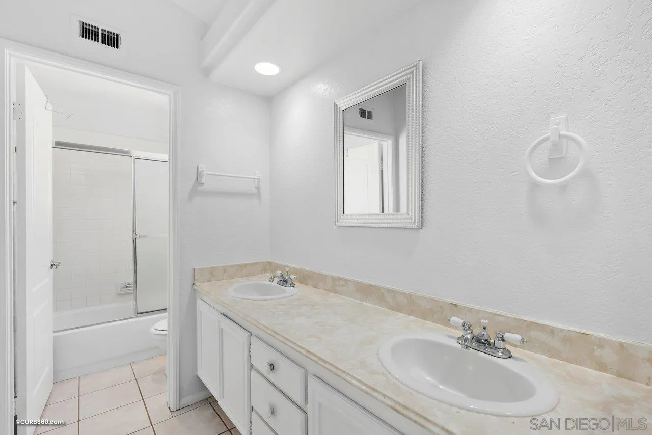 5138 Vía Madrid Oceanside, CA 92057 - Photo 27 of 32 a bathroom with a granite countertop sink a mirror and a bathtub