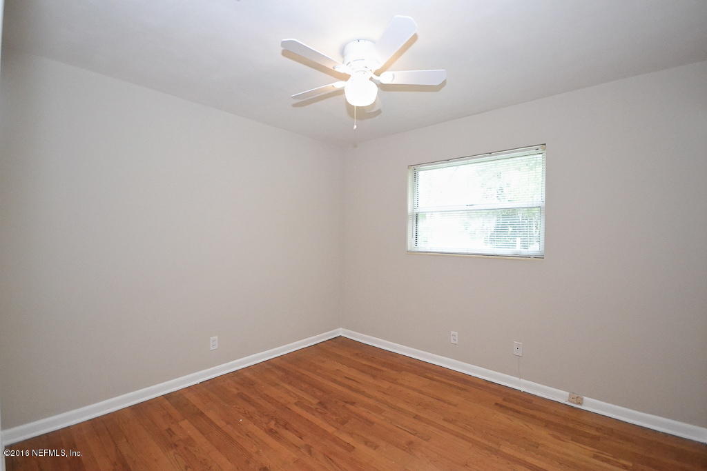6638 West Fincannon Road Jacksonville, FL 32277 - Photo 11 of 27 an empty room with wooden floor and ceiling fan