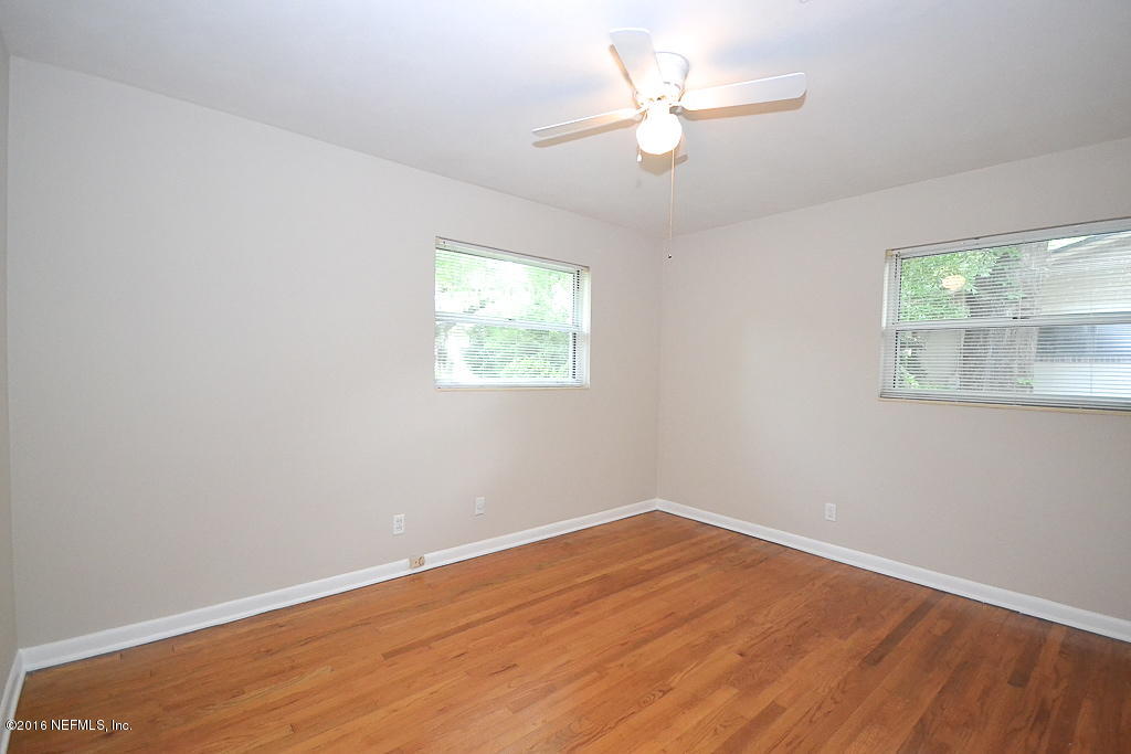 6638 West Fincannon Road Jacksonville, FL 32277 - Photo 13 of 27 a view of a room with wooden floor and a ceiling fan