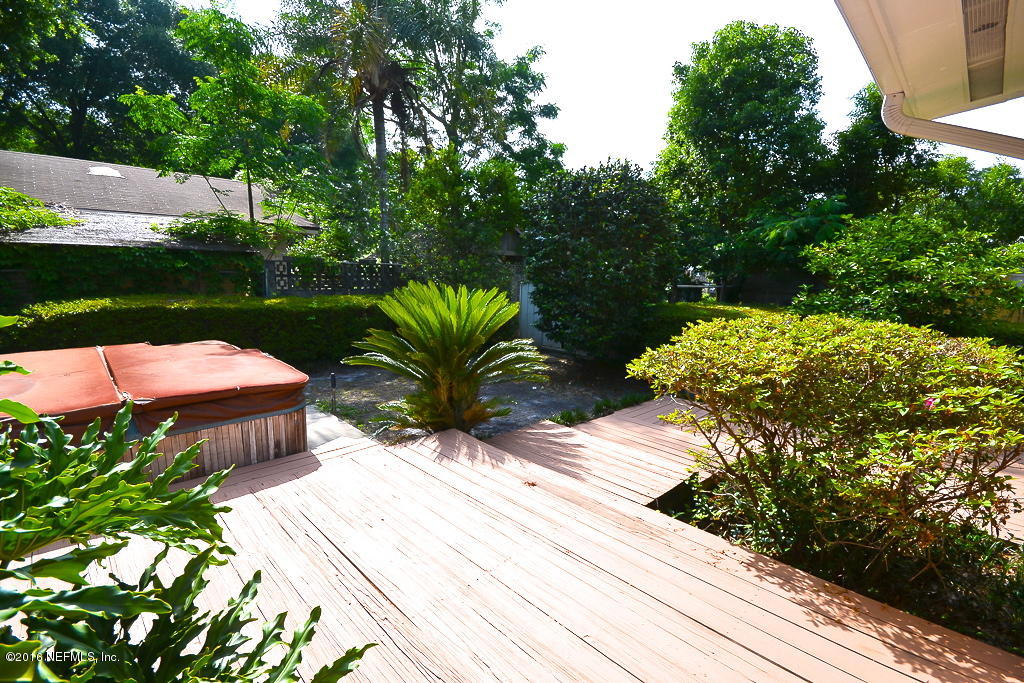 6638 West Fincannon Road Jacksonville, FL 32277 - Photo 19 of 27 a view of a patio with table and chairs potted plants and large tree