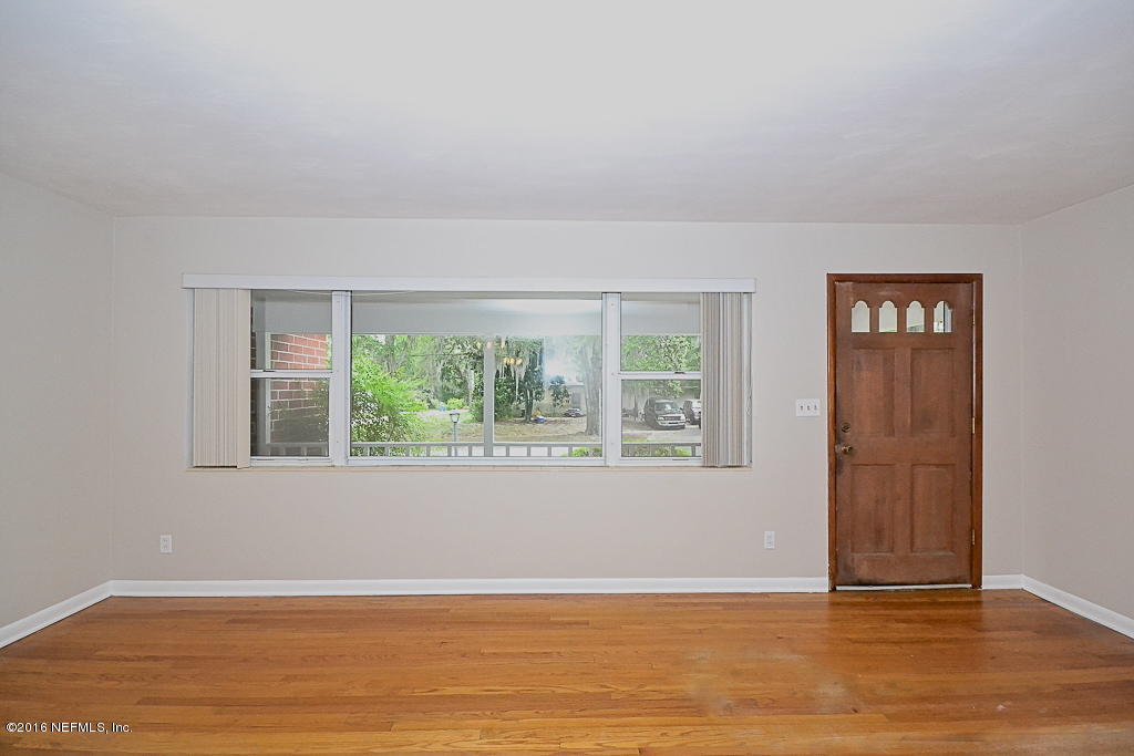 6638 West Fincannon Road Jacksonville, FL 32277 - Photo 2 of 27 an empty room with wooden floor and windows