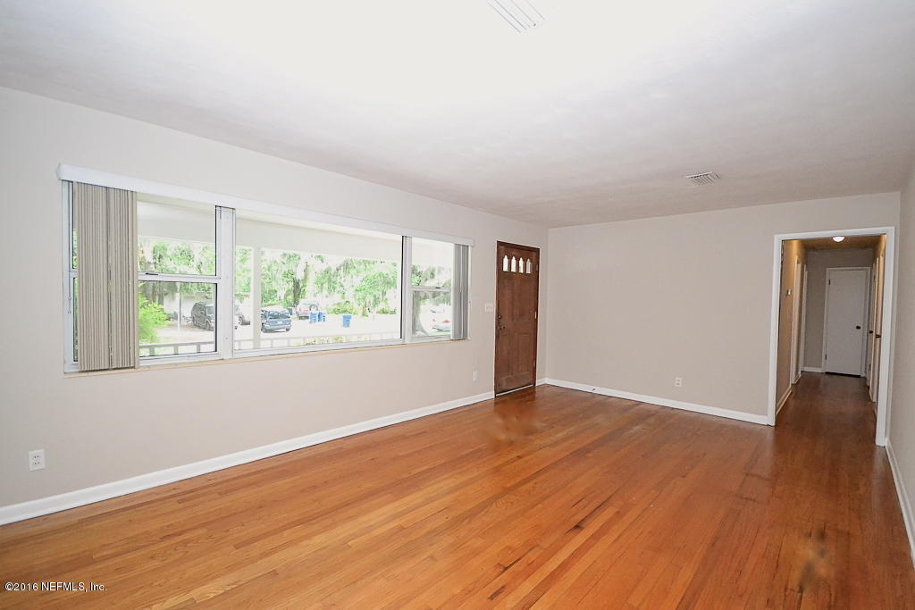 6638 West Fincannon Road Jacksonville, FL 32277 - Photo 3 of 27 an empty room with wooden floor and windows