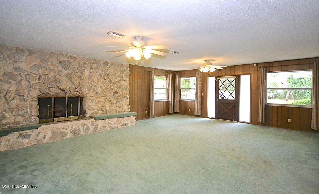 6638 West Fincannon Road Jacksonville, FL 32277 - Photo 6 of 27 a view of an empty room with a fireplace and a window