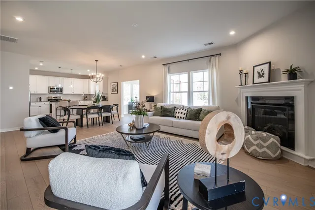 a living room with furniture a fireplace and kitchen view