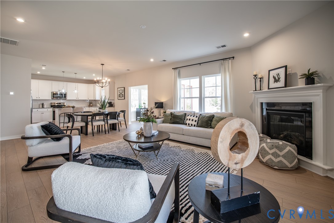 a living room with furniture a fireplace and kitchen view