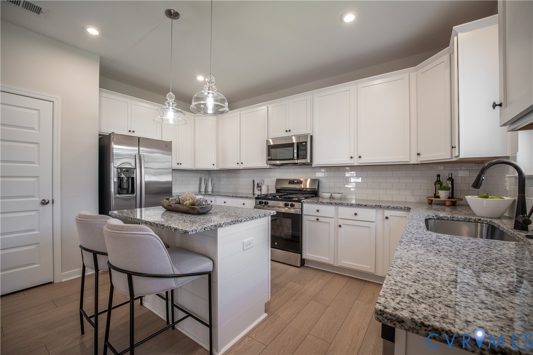 5318 Qualla Trace Chesterfield, VA 23832 - Photo 8 of 35 a kitchen with kitchen island granite countertop a sink counter space stainless steel appliances and cabinets