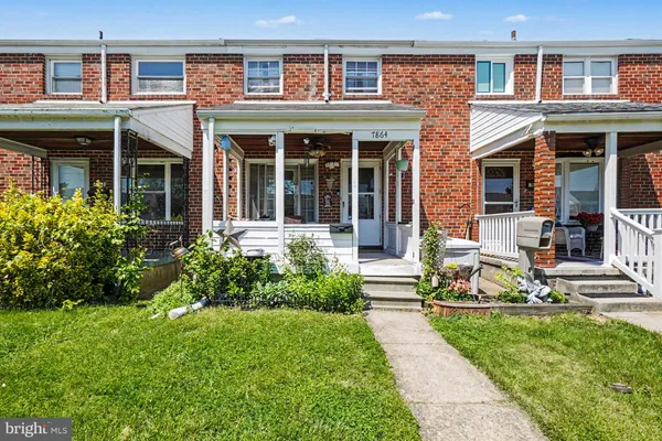 front view of a brick house with a yard