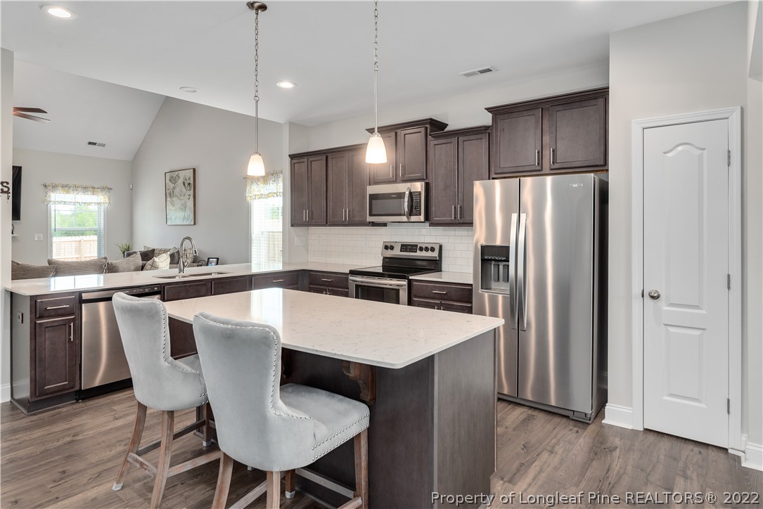 162 Trinity Road Raeford, NC 28376 - Photo 6 of 33 a large kitchen with a table chairs refrigerator and microwave