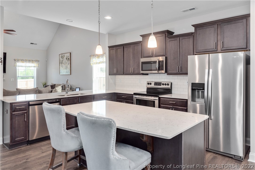 162 Trinity Road Raeford, NC 28376 - Photo 10 of 33 a kitchen with stainless steel appliances a table chairs microwave and refrigerator
