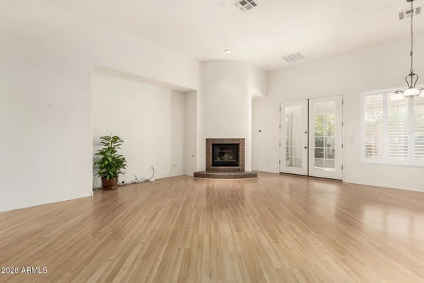 an empty room with wooden floor and a fireplace