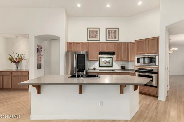 a kitchen with stainless steel appliances granite countertop a stove top oven a sink a counter space and cabinets