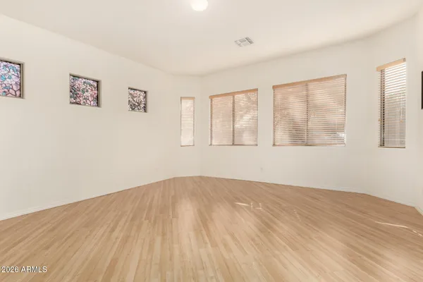 a view of empty room with wooden floor and fan