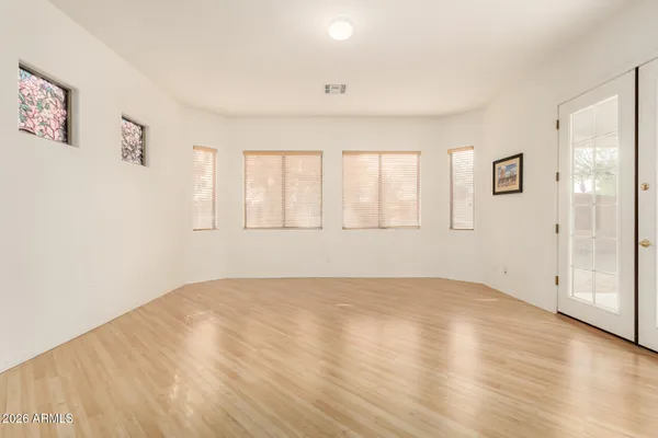 an empty room with wooden floor and windows