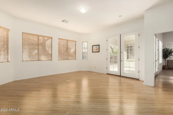 an empty room with wooden floor and windows