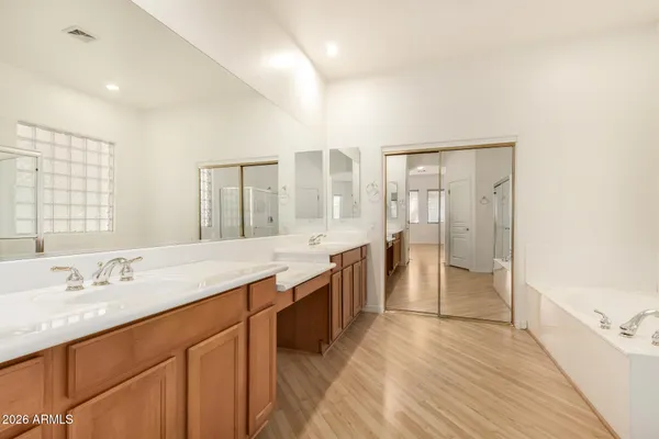 a spacious bathroom with a shower a sink and a mirror