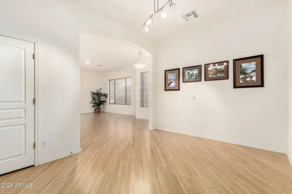 a view of a big room with wooden floor and windows