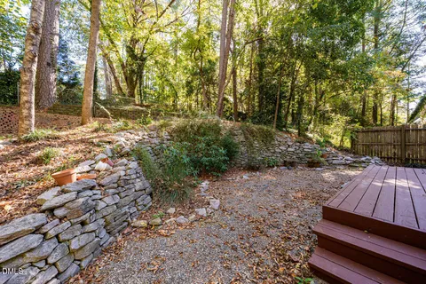 a view of backyard with wooden fence and large trees