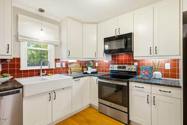 a kitchen with stainless steel appliances granite countertop a sink a stove and cabinets