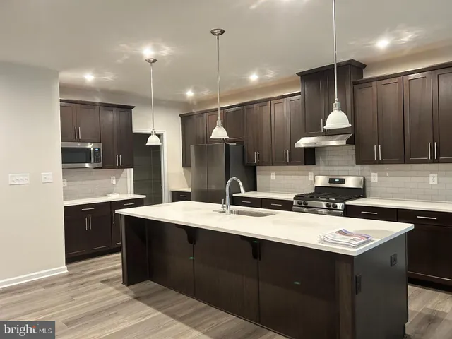a kitchen with a sink a stove a refrigerator and a cabinets