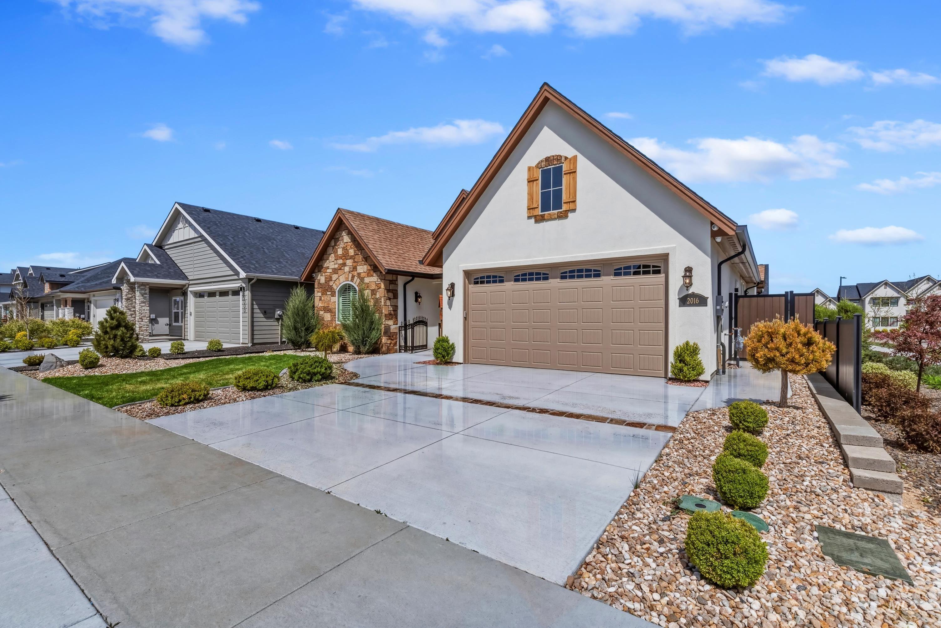 2016 East Mainacht Street Meridian, ID 83642 - Photo 35 of 36 Stone and stucco exterior with a prominent arched window and a two-car garage