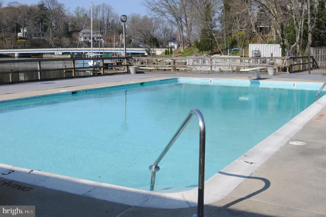 a view of swimming pool with outdoor seating and lake view