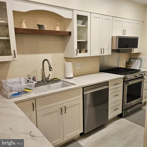 a kitchen with stainless steel appliances granite countertop a sink and a microwave