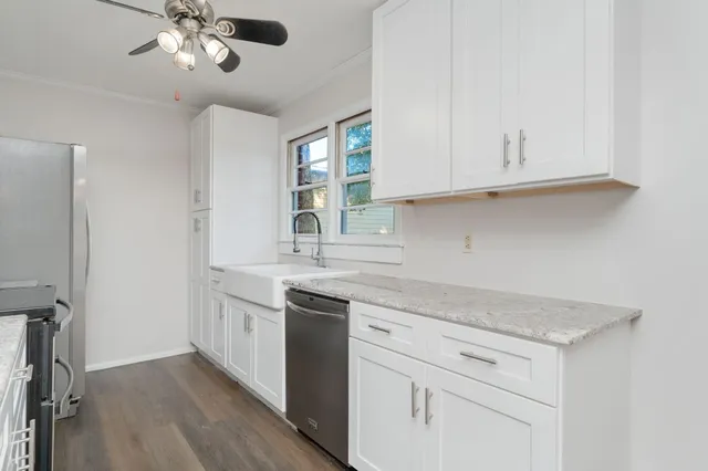 a kitchen with granite countertop white cabinets and white appliances
