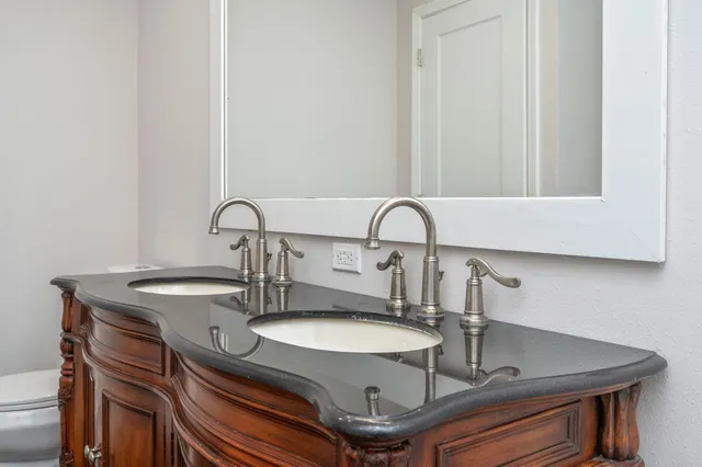a bathroom with a granite countertop sink a toilet and shower