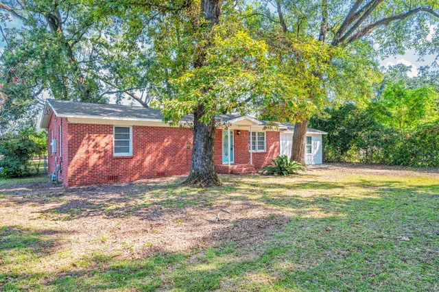 a view of a house with yard and tree s