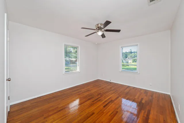 wooden floor in an empty room with a window