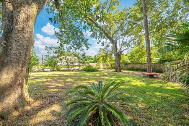 a view of wooden house with a small yard