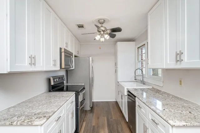 a kitchen with stainless steel appliances granite countertop a sink stove and refrigerator