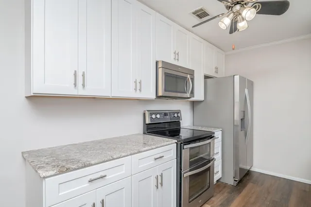 a kitchen with stainless steel appliances granite countertop a stove microwave and refrigerator
