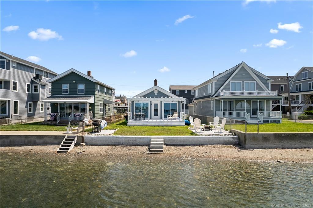 6 Virginia Street Milford, CT 06460 - Photo 1 of 1 a view of a large pool with a bench and lawn chairs under an umbrella