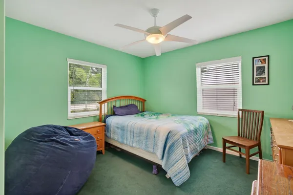 a bedroom with a bed chair and a window