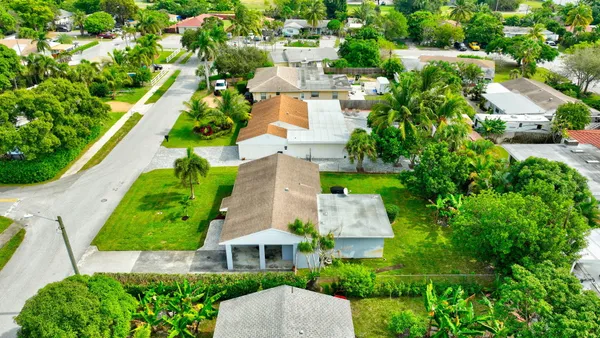 an aerial view of residential houses with outdoor space and trees