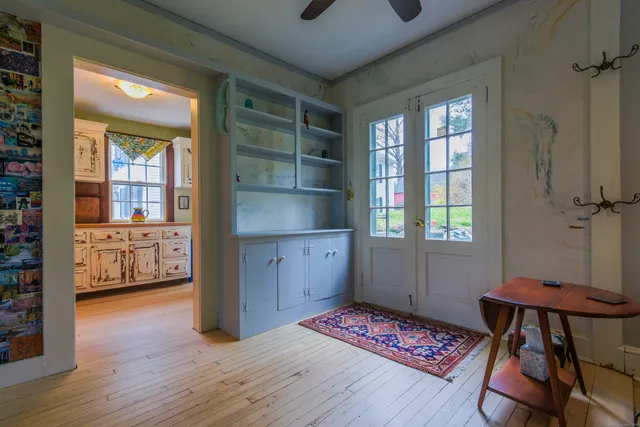 a utility room with stainless steel appliances granite countertop a sink and dishwasher a refrigerator with wooden floor