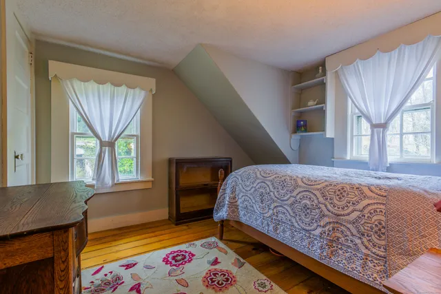 a bedroom with a bed and a lamp on dresser