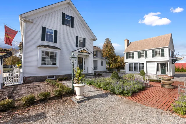 front view of two chairs and a table with the potted plants