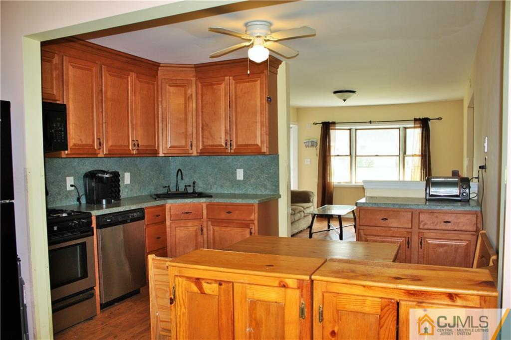 33 Ashley Road Edison, NJ 08817 - Photo 11 of 20 a kitchen with stainless steel appliances granite countertop a stove a sink a dining table and chairs with wooden floor