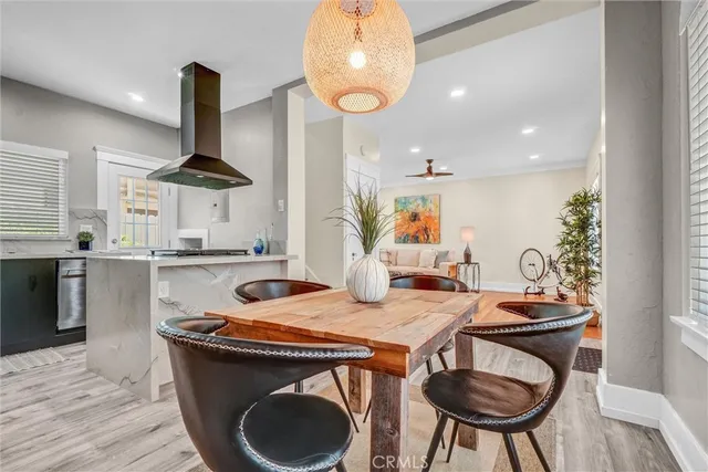 a kitchen with stainless steel appliances granite countertop a table chairs stove and wooden floor