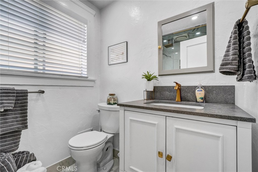 1616 East Ocean Boulevard, Unit 6 Long Beach, CA 90802 - Photo 26 of 37 a bathroom with a granite countertop toilet sink and mirror