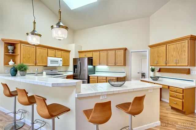 a kitchen with stainless steel appliances granite countertop a sink and dishwasher a stove with wooden cabinets