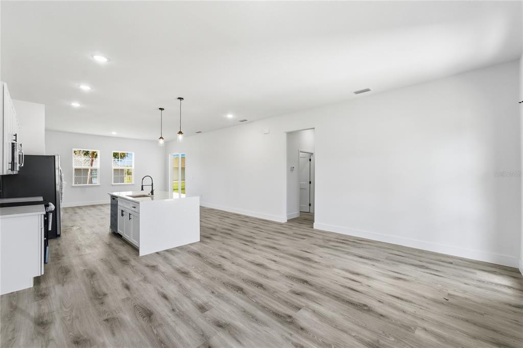 2600 Southwest 146th Pl Road Ocala, FL 34473 - Photo 35 of 40 a large living room with stainless steel appliances kitchen island wooden floors and fireplace